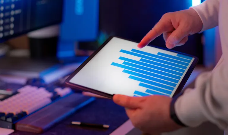 A strategist reviewing a bar chart of organic search traffic data on a tablet