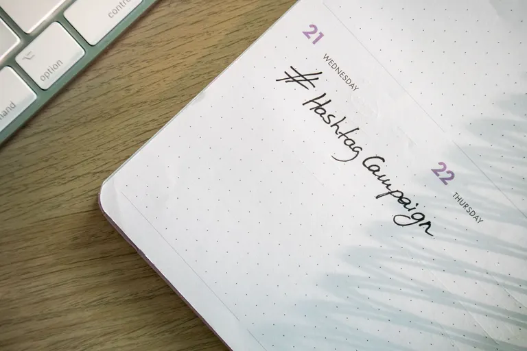 An open planner and campaign notes next to a keyboard, mapping out an email send schedule