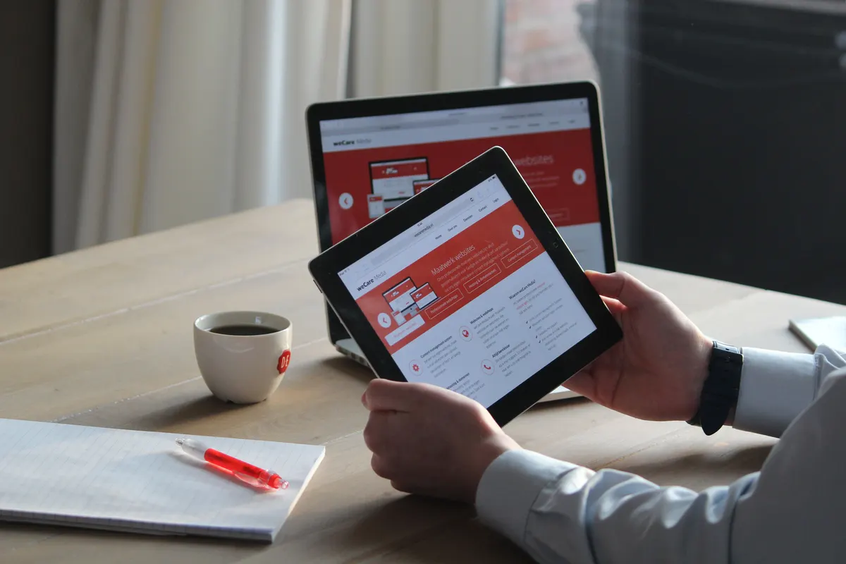 A designer testing a website prototype on a tablet while reviewing performance metrics
